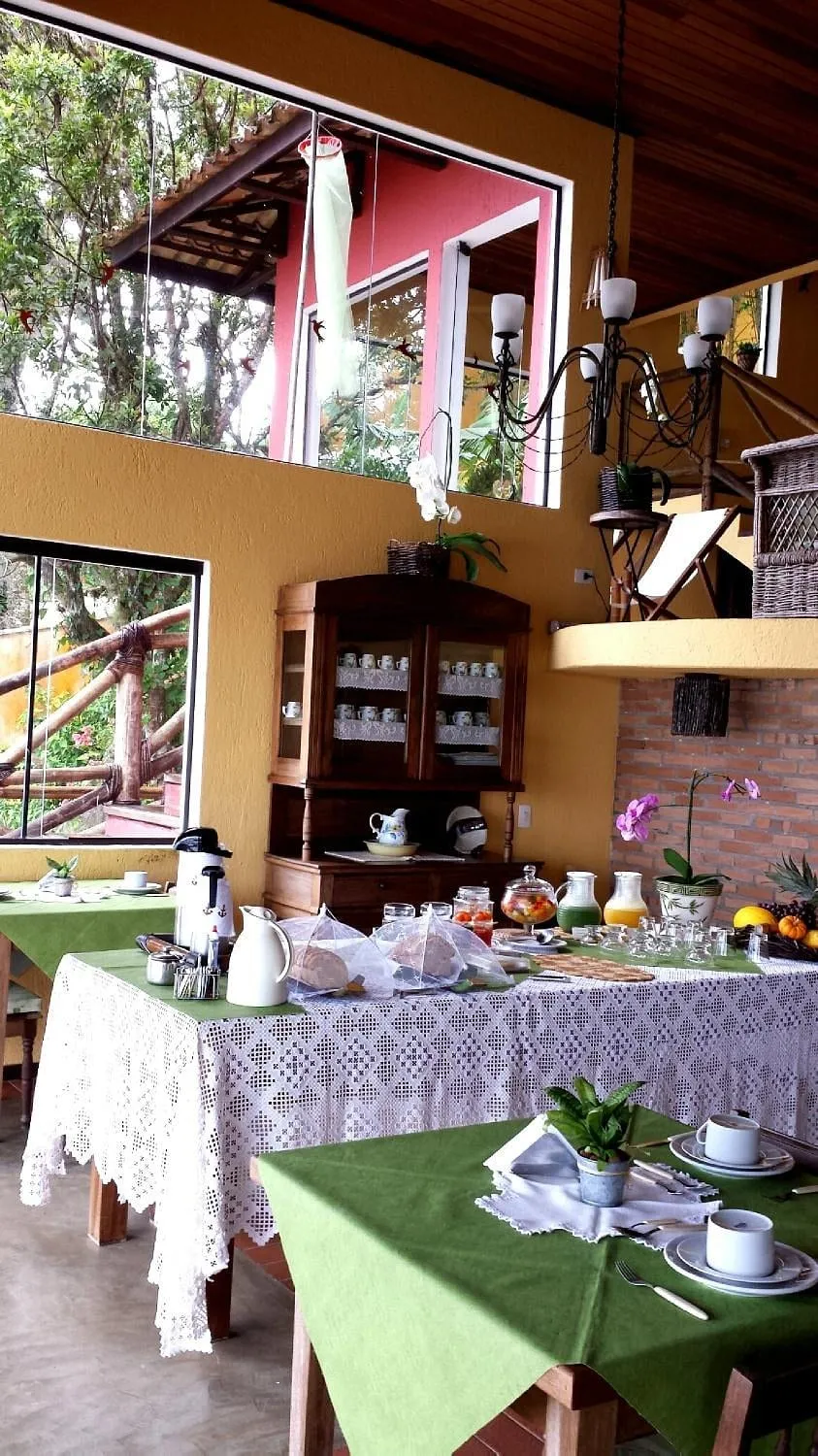 Mesa do café da manhã da Pousada Bambuza, com pães, sucos e frutas