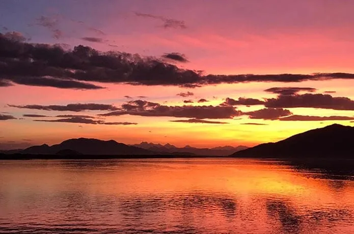 Céu rosa e laranja sobre a baía ao entardecer