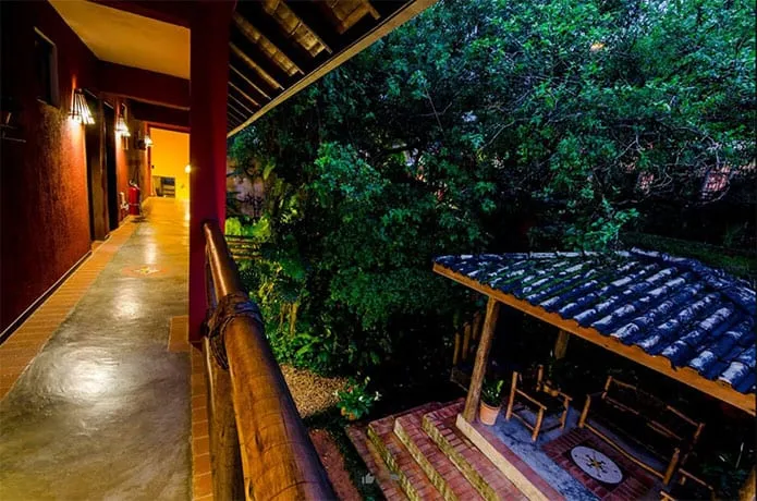 Corredor à noite com vista para o jardim e um quiosque coberto