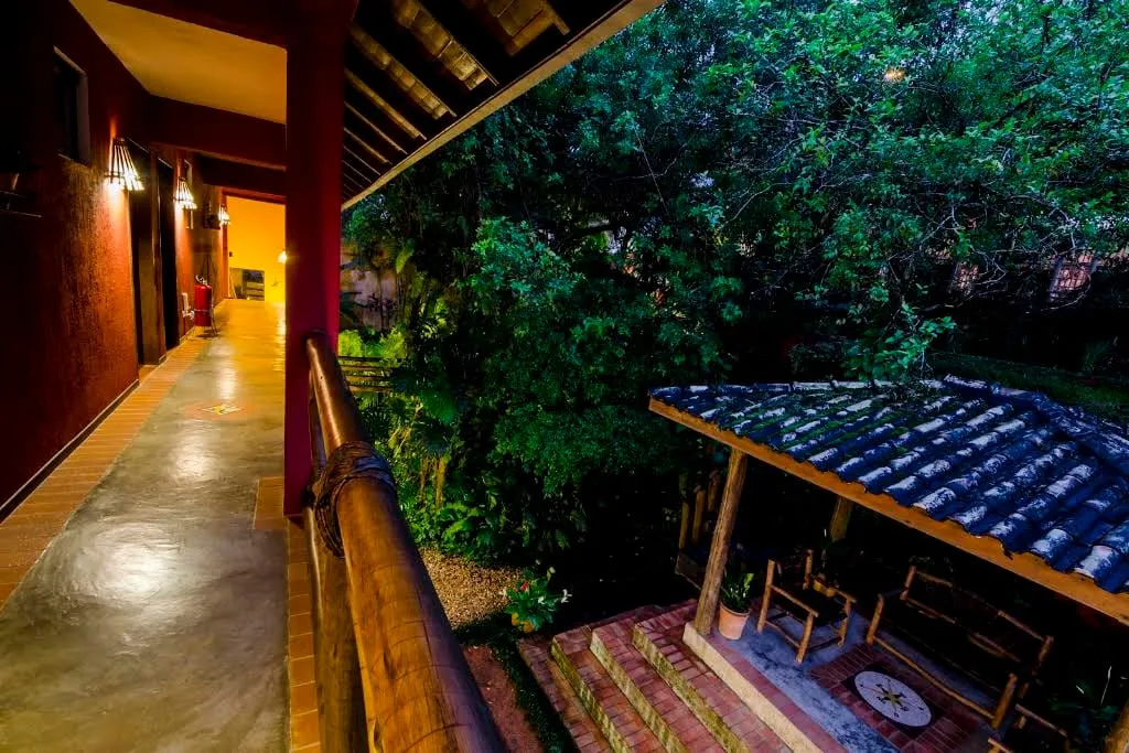 Corredor à noite com vista para o jardim e o quiosque