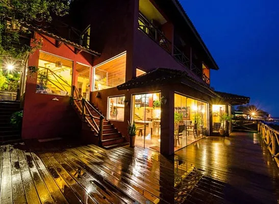Deck molhado à noite, janelas acesas da pousada