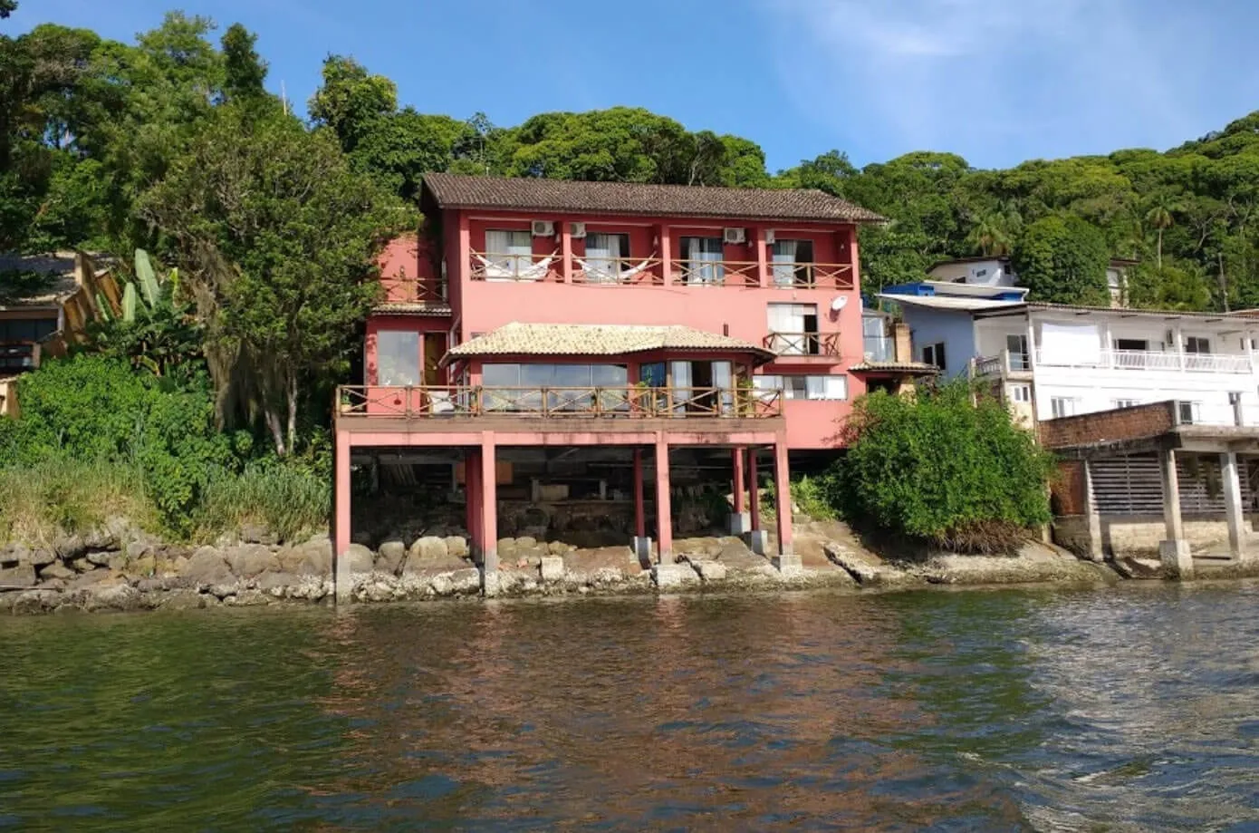 Fachada completa da pousada vista da água, maré baixa
