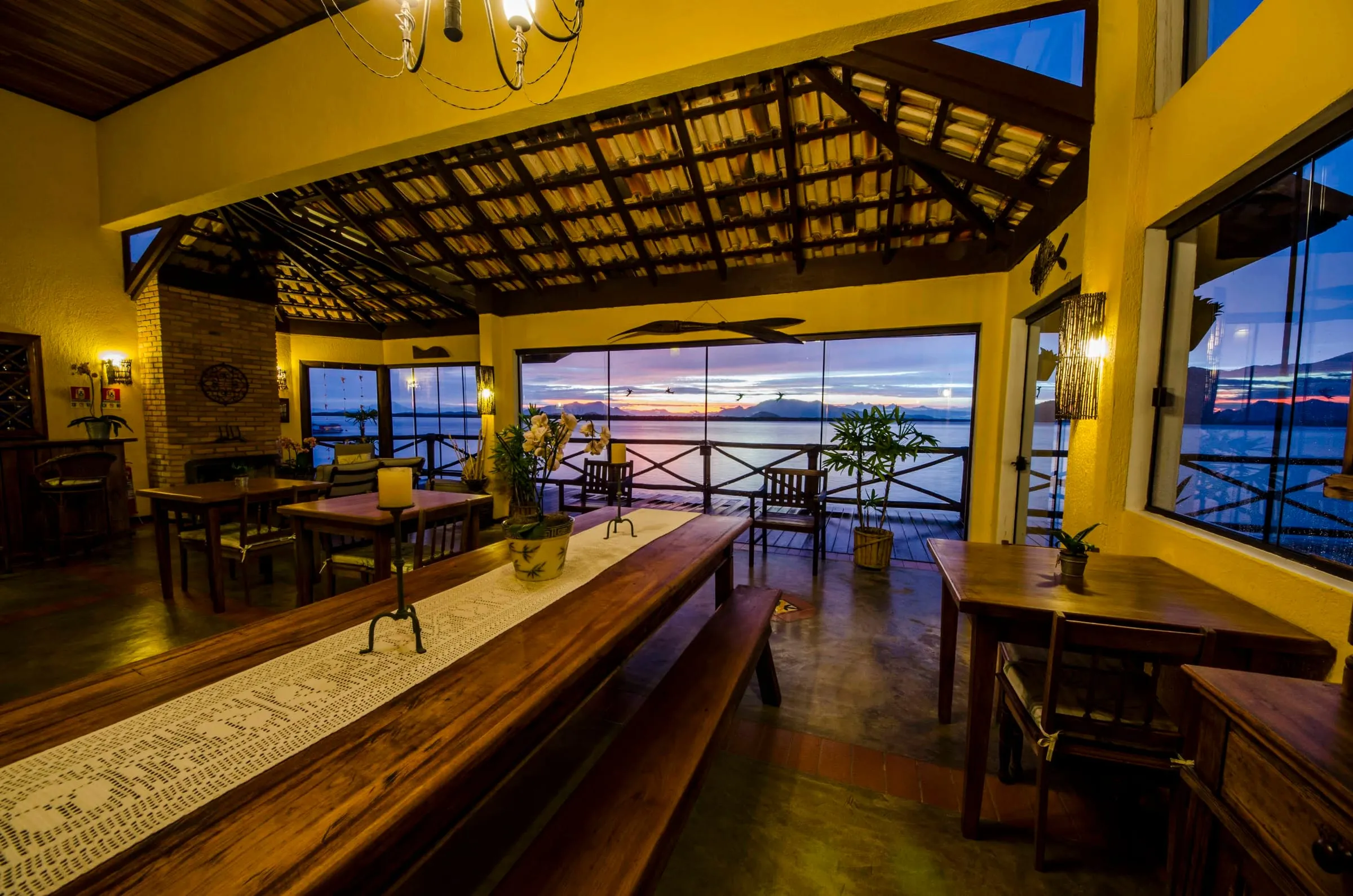 Mesa de jantar comprida com vista para o entardecer na baía