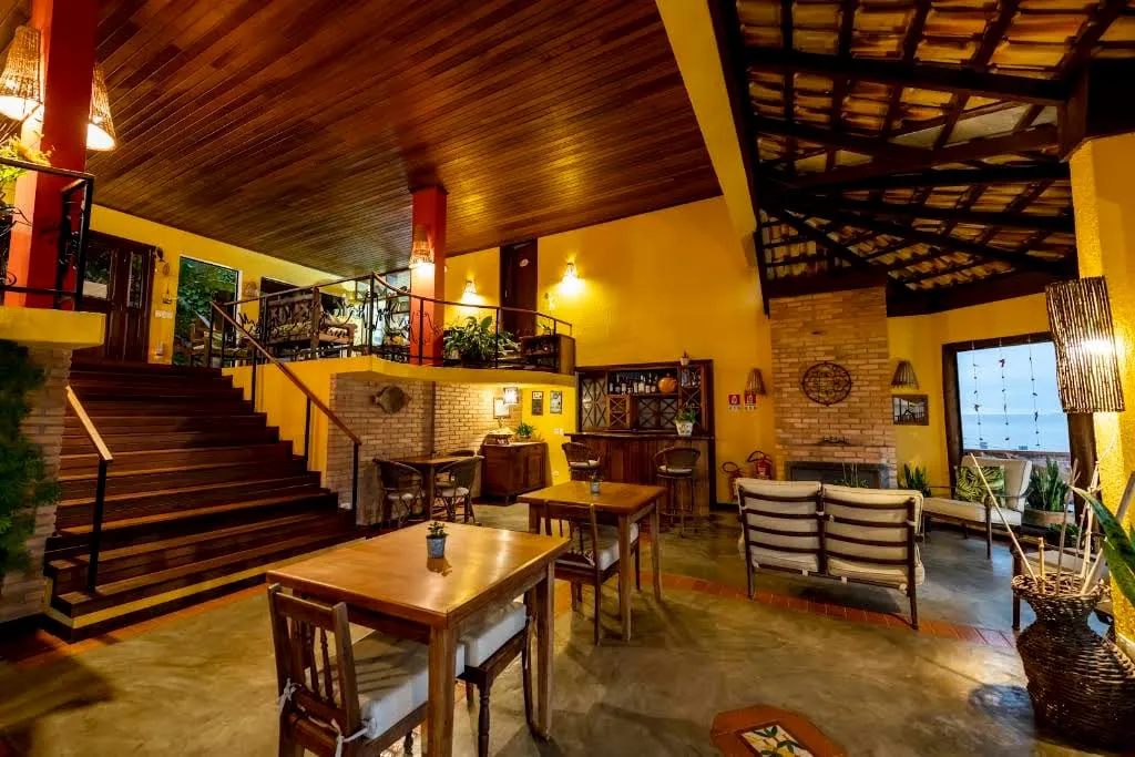 Sala de estar interna com escada de madeira e mesa de jantar