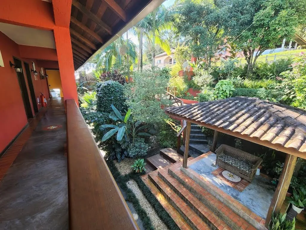 Vista da varanda para o jardim tropical e o quiosque coberto