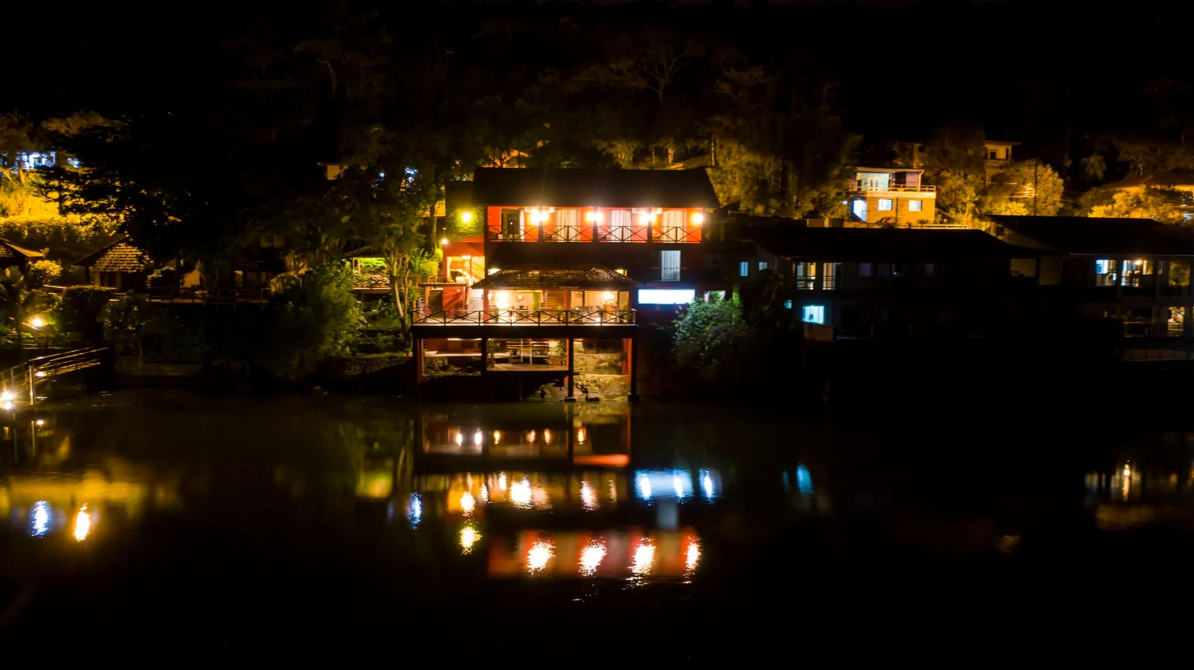 Vista aérea noturna da pousada com as luzes refletidas na baía